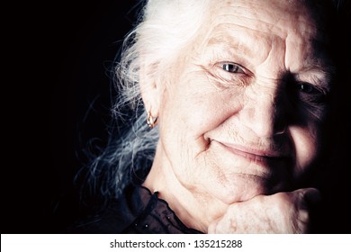 Portrait Of A Happy Senior Woman Smiling At The Camera. Over Black Background.