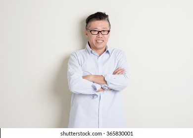 Portrait Of Happy Single Mature 50s Asian Man In Casual Business Smiling, Standing Over Plain Background With Shadow.