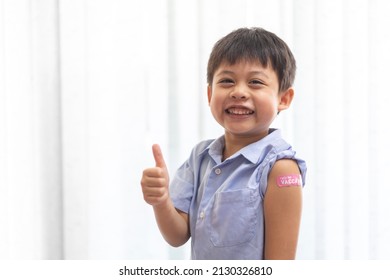 Portrait of happy smile vaccinated little asian kid boy children ages 5 to 11 years old posing show arm with medical plaster after Injection vaccine Covid-19 protection.coronavirus vaccination kid - Powered by Shutterstock