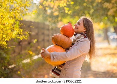 Portrait of happy smile woman with pumpkins in hand.