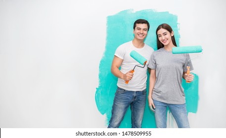 Portrait Of Happy Smiling Asian Couple Renovating Painting Wall House. Mother Father Repairing Paint Wall At Home. Man And Woman Together Love Lifestyle Concept With Copy Space.