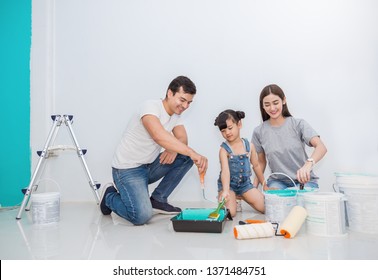 Portrait Of Happy Smiling Asian Family Renovating Painting Wall House. Mother Father And Child Daughter Repairing Paint Wall At Home. Together Love Asia Family  Lifestyle Concept With Copy Space.