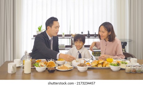 Portrait Of Happy Smiling Asian Family Eating Breakfast Food Together Before The Child Going To School At Home. Family Relationship. Love Of Father, Mother, And Son. People Lifestyle. Business Man.