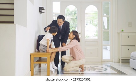 Portrait Of Happy Smiling Asian Family. A Student Prepaing To Go To School At Home Or House  In Family Relationship. Love Of Father, Mother, And Son. People Lifestyle.