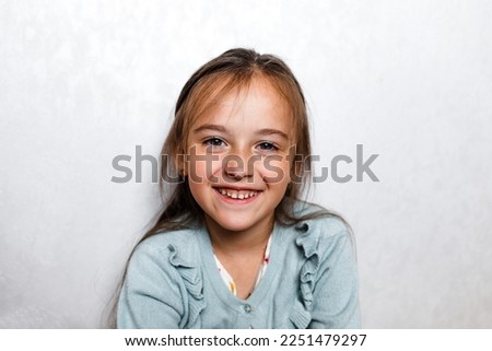 Portrait of a happy smiling baby girl on a light background. Laughing people. Positive emotions.