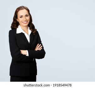Portrait of happy smiling brunette businesswoman in black confident suit, isolated over gray background. Business studio concept. Copy space blank area for some text.