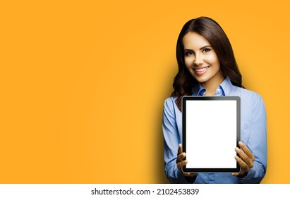 Portrait Of Happy Smiling Brunette Businesswoman Showing Mock Up Blank Tablet Pc, Touchpad, Ipad With Copy Space Area, Isolated Over Yellow Color Background. Confident Young Business Woman At Studio