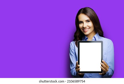 Portrait Of Happy Smiling Brunette Businesswoman Showing Mock Up Blank Tablet Pc, Ipad Touchpad, With Copy Space Area Over Violet Purple Background. Confident Young Business Woman At Studio. Executive