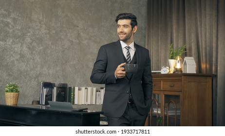 Portrait Of Happy Smiling Business Middle East Man Drinking A Cup Of Coffee, Chief Executive Officer Or CEO Person With Suit Standing In Room.