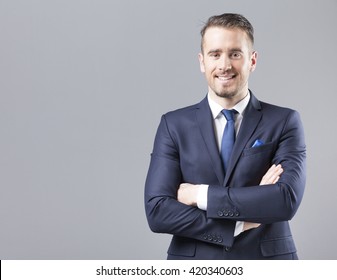 Portrait of a happy smiling businessman on grey background
