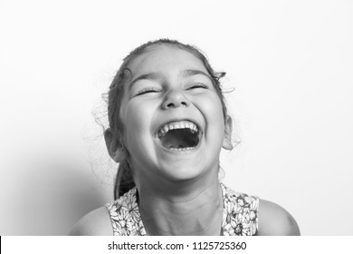 Portrait Of A Happy Smiling Child Girl. Laughing Child. Expressive Facial Expressions. Black And White Image. Space For Text.