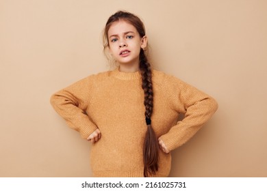 Portrait Of Happy Smiling Child Girl Long Pigtail Beige Sweater Grimace Beige Background