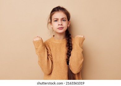 Portrait Of Happy Smiling Child Girl Long Pigtail Beige Sweater Grimace Beige Background