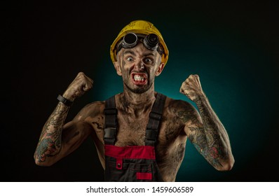 Portrait Of Happy Smiling Coal Miner With His Arms Crossed Against A Dark Background