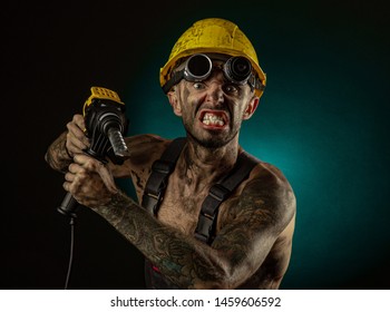 Portrait Of Happy Smiling Coal Miner With His Arms Crossed Against A Dark Background