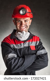 Portrait Of Happy Smiling Coal Miner With His Arms Crossed Against A Dark Background