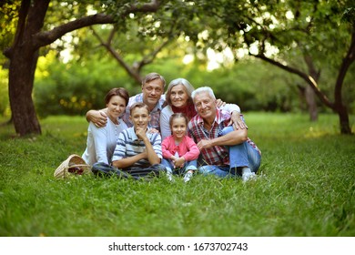 Porträt einer glücklich lächelnden Familie, die sich im Park entspannen