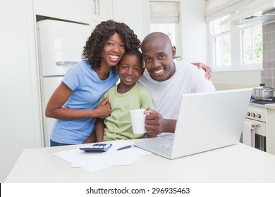 Portrait of happy smiling family using computer in the kitchen