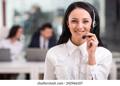 Portrait of happy smiling female customer support phone operator at workplace. - Shutterstock ID 242966107