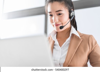 Portrait Of Happy Smiling Female Customer Support Phone Operator At Workplace. Asian