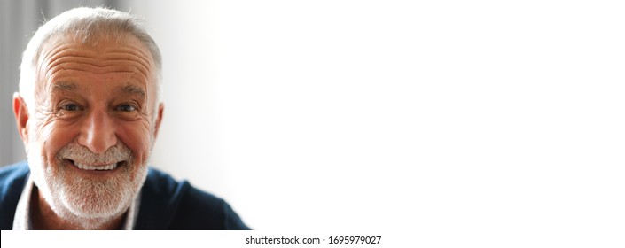 Portrait Of Happy Smiling Handsome Bearded Senior Man Looking At Camera With Copy Space Banner For Adding Text On White Wall Background.elderly And Older People.retirement Concept