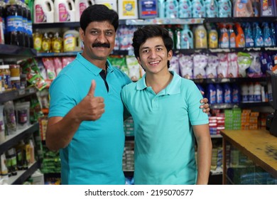 Portrait Of Happy And Smiling Indian Father And Son Purchasing In A Grocery Store. Buying Grocery For Home In A Supermarket. Cheerful Father And Son Holding A Product In Hand In A Shopping Mart.