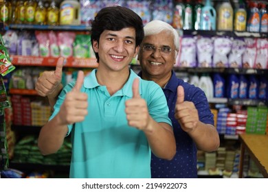 Portrait Of Happy And Smiling Indian Grandpa And Grandson Purchasing In A Grocery Store. Buying Grocery For Home In A Supermarket. Cheerful Grand Father And Grand Son Doing Thumbs Up.