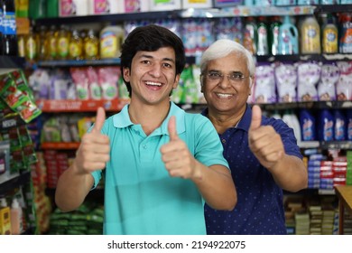 Portrait Of Happy And Smiling Indian Grandpa And Grandson Purchasing In A Grocery Store. Buying Grocery For Home In A Supermarket. Cheerful Grand Father And Grand Son Doing Thumbs Up.