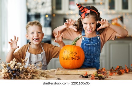 Portrait Of Happy Smiling Kids Boy And Girl Looking At Camera  And Scary Gesture While Preparing Halloween Handmade Home Decorations, Brother And Sister Enjoying Painting Pumpkins