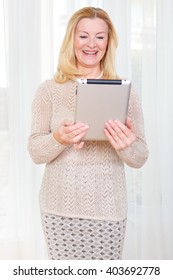 Portrait Of Happy Smiling Rich Senior Business Woman 60-65 Years Old, Using Ipad Tablet Pc Computer Reading Ebook In Office