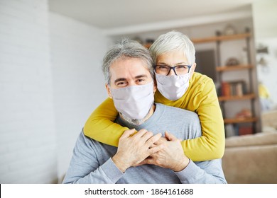 Portrait Of Happy Smiling Senior Couple Wearing Protective Masks At Home 