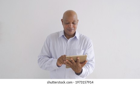 Portrait Of Happy Smiling Senior Old Elderly Business Black African American Man Person Typing On Tablet Computer In Technology Device Isolated On White Background.