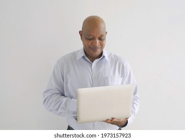 Portrait Of Happy Smiling Senior Old Elderly Business Black African American Man Person Typing On Computer Laptop Notebook In Technology Device Isolated On White Background.