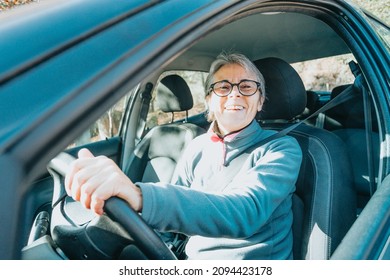 Portrait Of A Happy Smiling Senior Woman Learning To Drive A Car. Safety Drive. Learning New Hobby, Habit And Skill For This New Year. Elderly Person Approving The Driving License.