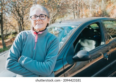 Portrait Of A Happy Smiling Senior Woman Outside Car Learning To Drive A Car. Safety Drive. Learning New Hobby, Habit And Skill For This New Year. Elderly Person Approving The Driving License.