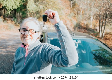 Portrait Of A Happy Smiling Senior Woman Learning To Drive A Car Holding The Car Key To Camera.Safety Drive.Learning New Hobby,habit And Skill For This New Year.Old Person Approving Driving License