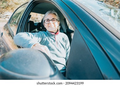 Portrait Of A Happy Smiling Senior Woman Learning To Drive A Car. Safety Drive. Learning New Hobby, Habit And Skill For This New Year. Elderly Person Approving The Driving License.