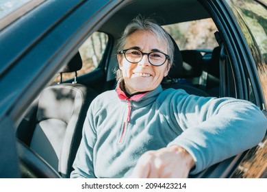 Portrait Of A Happy Smiling Senior Woman Learning To Drive A Car. Safety Drive. Learning New Hobby, Habit And Skill For This New Year. Elderly Person Approving The Driving License.