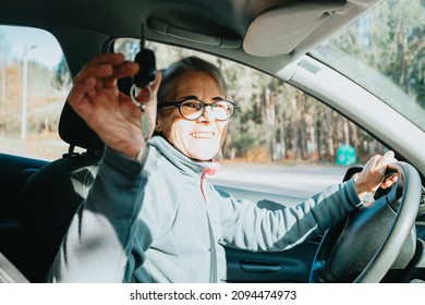 Portrait Of A Happy Smiling Senior Woman Learning To Drive A Car Holding The Car Key To Camera.Safety Drive.Learning New Hobby,habit And Skill For This New Year.Old Person Approving Driving License