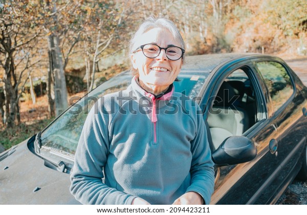 Portrait of a happy smiling senior woman outside
car learning to drive a car. Safety drive. Learning new hobby,
habit and skill for this new year. Elderly person approving the
driving license.