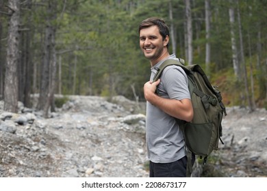 Portrait of happy smiling tourist man 30-35 years old with backpack hiking in national park - Shutterstock ID 2208673177