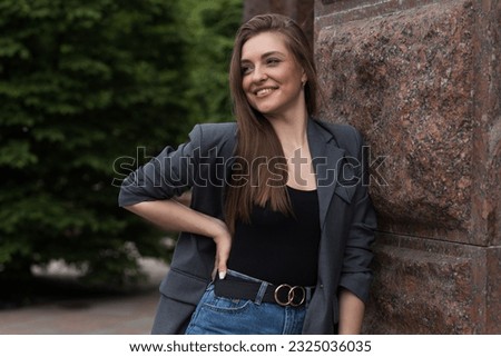 Portrait of a happy smiling woman in casual clothes while walking around the city. Portrait of a young attractive girl in suit. Lifestyle concept.