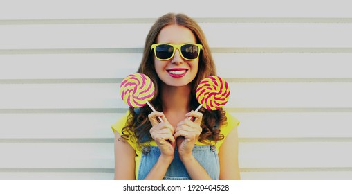 Portrait of happy smiling woman with lollipop on a white background