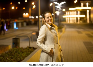 Portrait Of Happy Smiling Woman Walking On Street At Night