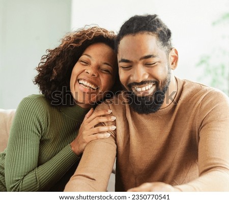 portrait of happy smiling young couple using a laptop computer and a credit card  for online shopping at home, technology and internet use in everyday life concept
