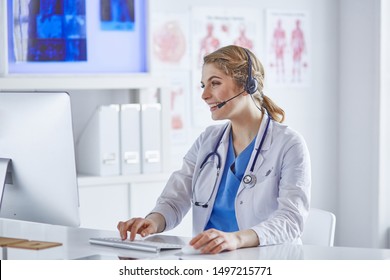 Portrait of a happy smiling young doctor in headset in office