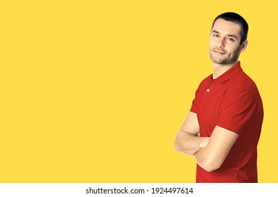 Portrait Of Happy Smiling Young Man In Red Smart Casual Clothing With Crossed Arms, Over Yellow Color Background. Male Model At Studio. Copy Space Empty Area Place For Text.