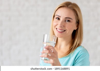 Portrait von glücklich lächelnden jungen Frau mit Glas Süßwasser. Konzept eines gesunden Lebensstils