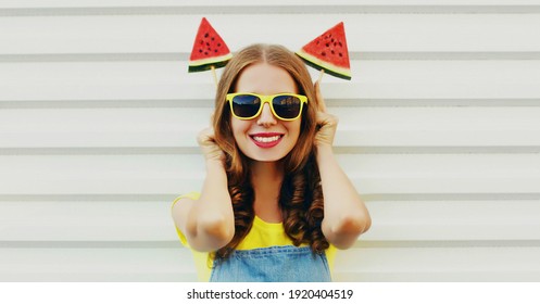 Portrait of happy smiling young woman with ice cream shaped slice of watermelon on a white background
