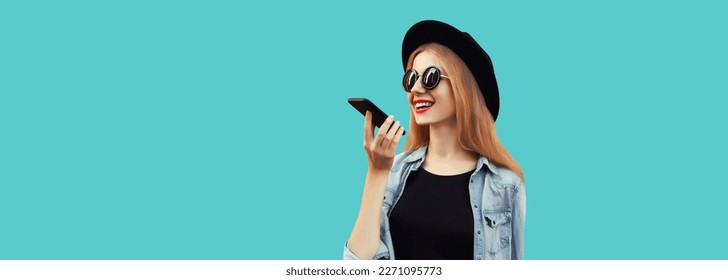 Portrait of happy smiling young woman with smartphone using voice command recorder, assistant or takes calling isolated on blue background, copy space - Powered by Shutterstock